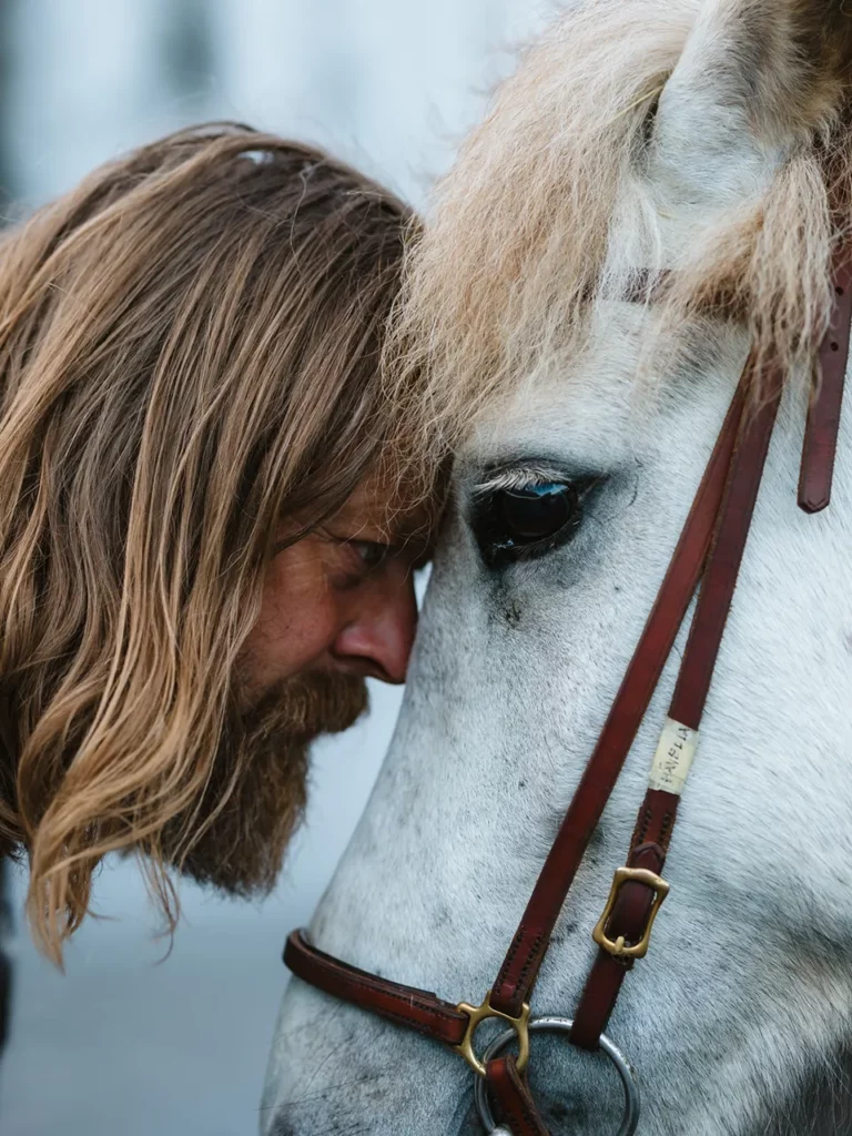 Mr Iceland with a white horse of his farm