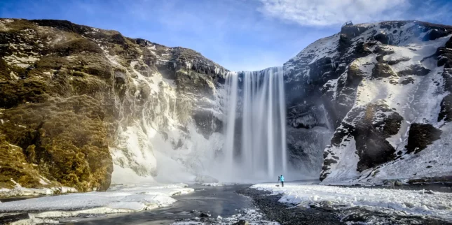 Skogafoss waterfall pouring over icy cliffs in Iceland